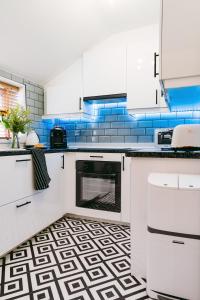 卡迪夫Central Retreat的厨房配有白色橱柜和蓝色瓷砖