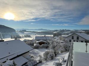 Ferienhaus Alpenblick的一座被雪覆盖的小镇,太阳照耀着