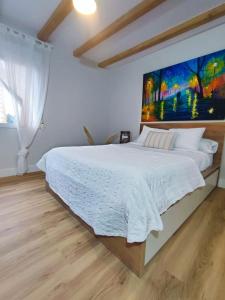 希洪El Hogarin de Veronica的卧室配有一张大床,墙上挂有绘画作品