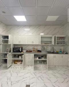 SinādilElva farm的厨房配有白色橱柜和瓷砖地板。