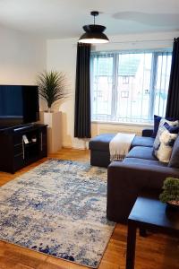 伯明翰Villa Retreat Birmingham的客厅配有蓝色的沙发和地毯。