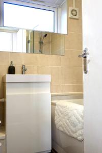 伯明翰Villa Retreat Birmingham的一间带水槽、浴缸和镜子的浴室