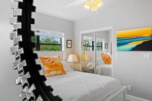 可可比奇Midtown Cottage - In the heart of Cocoa Beach的卧室配有一张床,墙上挂有绘画作品