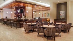 圣胡安Hyatt Place San Juan的一间带桌椅的餐厅和一间酒吧