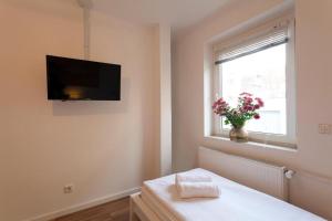 汉诺威City Apart Hannover的卧室设有壁挂式电视和窗户。