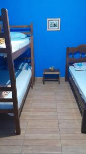 伊塔蒙蒂Casa e camping Reinaldo e Julia recanto das árvores的客房设有两张双层床和蓝色的墙壁。