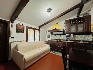 桑格罗堡[FREE PARKING] La Bianca Neve Cottage的带沙发的客厅和厨房