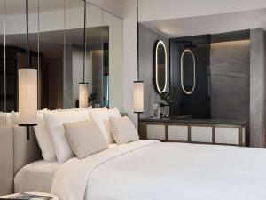 阿基欧斯尼古拉斯NIKO Seaside Resort MGallery的卧室配有一张白色大床和镜子