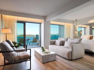 阿基欧斯尼古拉斯NIKO Seaside Resort MGallery的一间卧室配有一张床,客厅配有沙发