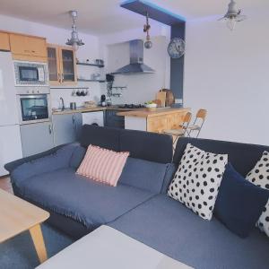 阿里纳加Casa Faro de Arinaga的一间带蓝色沙发的客厅和一间厨房