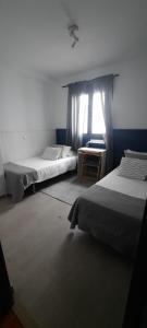 阿里纳加Casa Faro de Arinaga的一间卧室设有两张床和窗户。