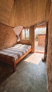 利文斯顿Muke Village Guest House的一间带床的卧室,位于带窗户的房间内