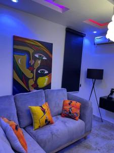 哈科特港Modern 1bedroom Duplex的客厅配有带枕头的沙发和绘画