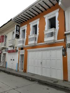AguadasHotel Casa Blanca的一座橙色和白色的建筑,设有白色车库