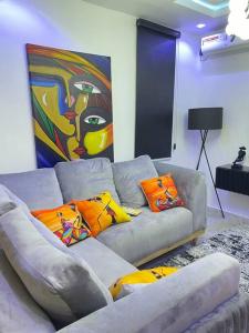 哈科特港Modern 1bedroom Duplex的客厅配有带色彩缤纷枕头的灰色沙发