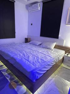 哈科特港Modern 1bedroom Duplex的一间卧室配有一张带蓝色棉被的床