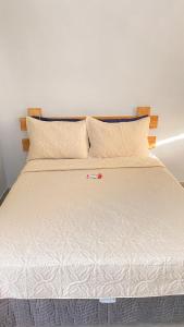 布希奥斯Espaço Zoey的一张带白色床单和枕头的床