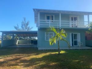帕苏迪托雷斯Casa Praia Ribeiro SC的前面有棕榈树的房子