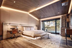 济州市琥珀璞山度假村济州的一间卧室配有一张大床、一张桌子和一张书桌