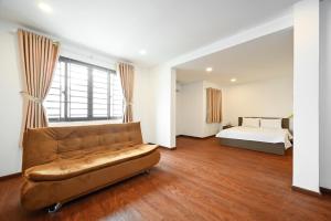 胡志明市YoKo Airport Saigon Hotel的客厅配有沙发和1张床
