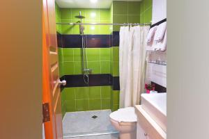 马尼拉AMORE HOTEL MANILA的绿色和黑色的浴室设有卫生间和淋浴。