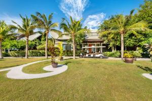 华欣Phukalini Luxury Pool Villa & Onsen-SHA Plus Certified的前面有棕榈树的房子