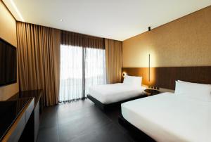 公主港The Funny Lion - Puerto Princesa的酒店客房设有两张床和电视。