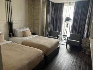 合艾S哈代酒店的酒店客房设有两张床和窗户。
