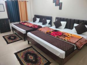 AyodhyaHotel The Ramam的地板上带垫子的客房内的三张床