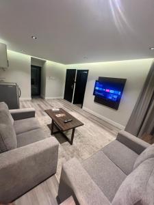 达曼Amwaj Alshatie Furnished Units的客厅配有2张沙发和1台平面电视