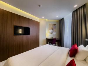 阿拉木图哈萨克斯坦酒店的一间酒店客房,配有一张床和一台墙上的电视