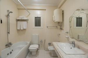 开罗Zamalek Serviced Apartments by Brassbell的白色的浴室设有浴缸、卫生间和水槽。