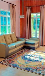 峇株巴辖Teratak Kayu Homestay的带沙发和地毯的客厅