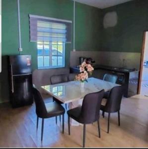 峇株巴辖Teratak Kayu Homestay的客厅配有桌椅和沙发