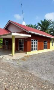 峇株巴辖Teratak Kayu Homestay的红色和黄色的建筑,有红色的屋顶