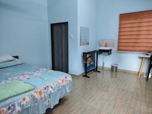 BalingHomestay Teratak D`kemangi with Private Pool的一间卧室配有一张床和一张带窗户的书桌