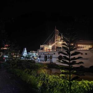 Ban Thung SamoeBoat &​ House Resort​的一座白色的大建筑,晚上有灯