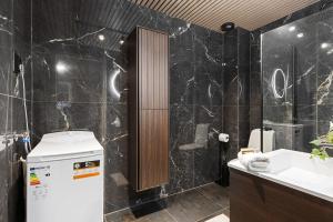 卑尔根Apartments Bergen free parking的浴室设有黑色大理石墙壁和水槽。