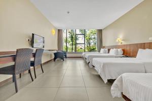 新加坡Siloso Beach Resort - Sentosa的酒店客房设有三张床和一张书桌