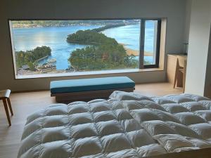 宫津市玄妙庵日式旅馆的一张大床,位于带大窗户的房间里