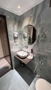 苏拉特Hotel The Excellency的一间带水槽和镜子的浴室