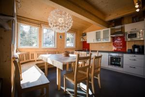 图拉彻霍赫Alpenpark Turrach by ALPS RESORTS的厨房配有桌椅和吊灯。