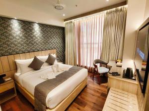 孟买Maxxvalue Hotel MIDC - Andheri的酒店客房,配有床和电视