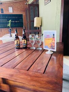 锡吉里亚Thal Sewana Home Stay的木桌旁的两瓶啤酒和酒杯