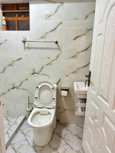 埃尔多雷特Regency Stays III的浴室设有白色卫生间和大理石墙壁。
