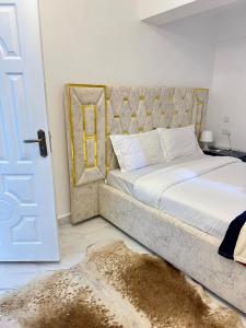 埃尔多雷特Regency Stays III的一间卧室配有一张大床,另一扇门铺有地毯。
