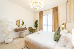 迪拜FAM Living - Serene 1BR Haven in Madinat Jumeirah Living的白色卧室设有一张大床和镜子