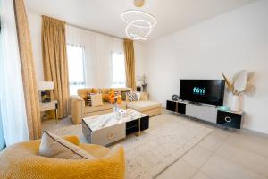 迪拜FAM Living - Serene 1BR Haven in Madinat Jumeirah Living的带沙发和电视的客厅