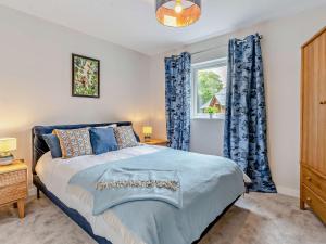 3 Bed in Gower 91729的一间卧室配有一张带蓝色窗帘的床和一扇窗户