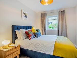 3 bed property in Gower South Wales 91727的一间卧室配有一张带蓝色床头板的床和窗户
